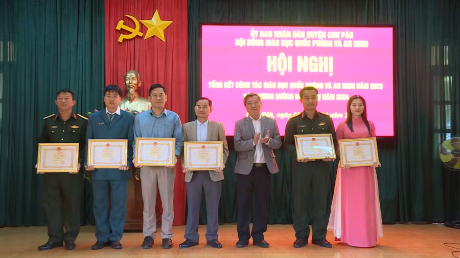 Ông Nguyễn Ngọc Thanh (thứ 3 từ phải qua)-Phó Chủ tịch UBND huyện Chư Păh tặng giấy khen cho các tập thể, cá nhân có thành tích tốt trong công tác giáo dục quốc phòng và an ninh năm 2023. Ảnh: V.Đ