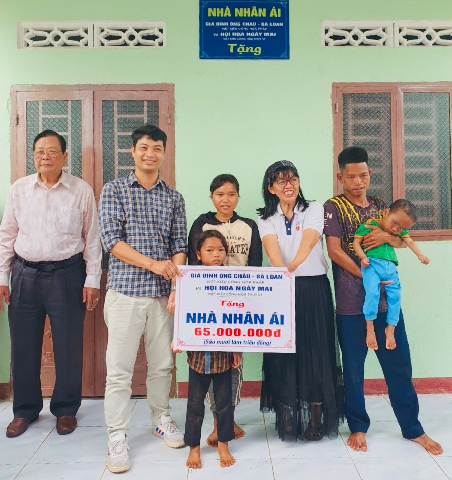 Đại diện Hội Hoa Ngày Mai (Việt kiều tại Thụy Sĩ) hỗ trợ 65 triệu đồng để xây nhà nhân ái cho cháu Rơ Lan Nhâm là nạn nhân chất độc da cam. Ảnh: Xuân Thủy