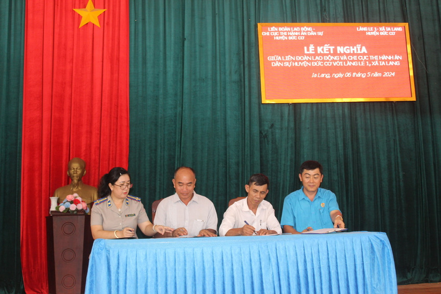 Đại diện Liên đoàn Lao động huyện Đức Cơ, Chi cục Thi hành án dân sự huyện và làng Le 1 ký giao ước kết nghĩa. Ảnh: Đinh Yến