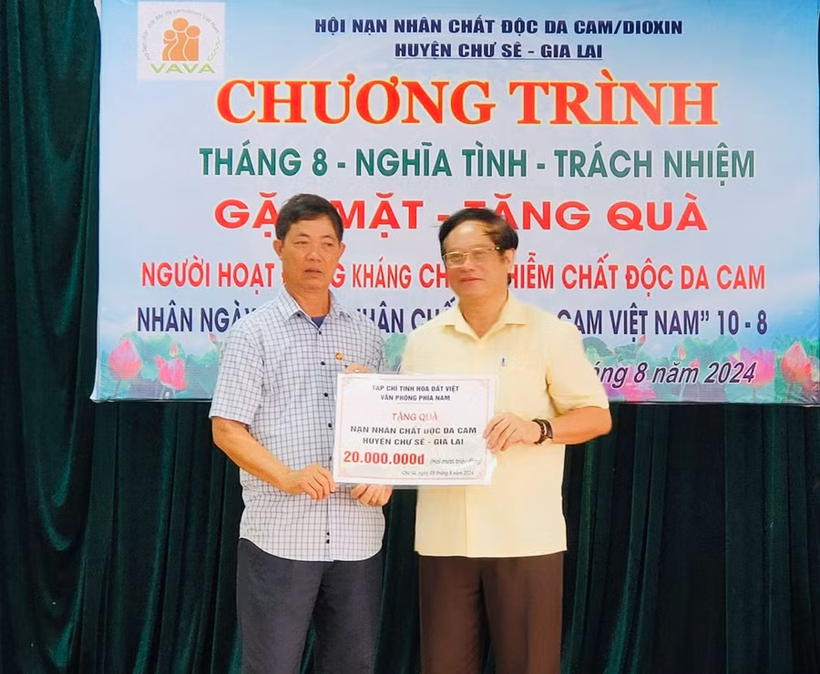 Ông Nguyễn Dũng (bên phải; đại diện Tạp chí Tinh hoa Đất Việt Văn phòng phía Nam) đã trao biển tượng trưng tặng 20 triệu đồng cho các nạn nhân chất độc da cam và hộ nghèo huyện Chư Sê vào dịp tháng 9 sắp tới. Ảnh: Đinh Yến