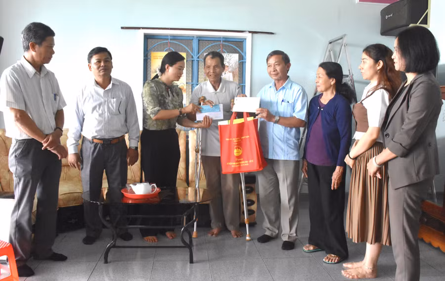 Trưởng ban Tuyên giáo Tỉnh ủy Huỳnh Thế Mạnh (thứ 4 từ phải qua) thăm, tặng quà thương binh Đinh Công Thắm, thôn Tân Bình, xã Tân An, huyện Đak Pơ. Ảnh: Đinh Yến