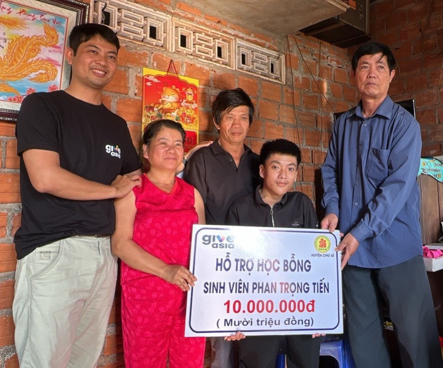 Ông Nguyễn Xuân Thủy (bìa phải)-Chủ tịch Hội Nạn nhân chất độc da cam/dioxin huyện Chư Sê trao học bổng cho em Phan Trọng Tiến là sinh viên, nạn nhân chất độc da cam. Ảnh: Đinh Yến