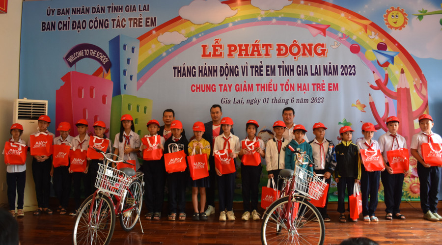 Đại diện Quỹ Bảo trợ trẻ em tỉnh Gia Lai, Công ty TNHH Bảo hiểm Nhân thọ AIA Việt Nam trao quà và xe đạp cho học sinh nghèo vượt khó. Ảnh: Đinh Yến