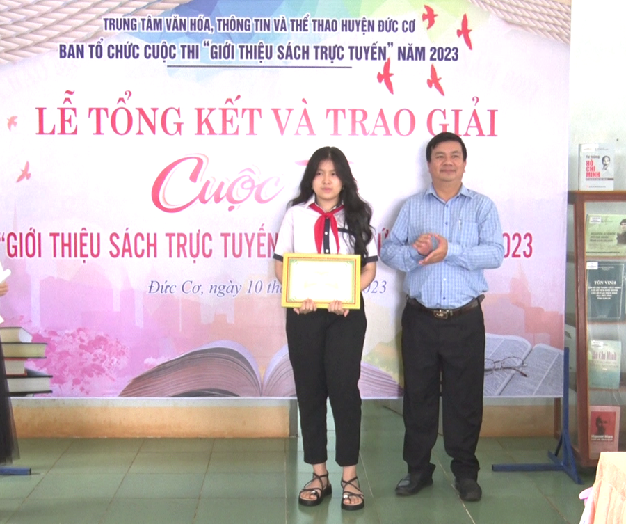 Ông Nguyễn Vũ Hiền-Giám đốc Trung tâm Văn hóa-Thông tin và Thể thao huyện Đức Cơ trao giải nhất Cuộc thi cho em Lê Minh Phương, lớp 8D, Trường THCS Nguyễn Hiền giới thiệu cuốn sách “Chiến binh cầu vồng”. Ảnh: Thanh Tịnh Ông Nguyễn Vũ Hiền-Giám đốc Trung tâm Văn hóa-Thông tin và Thể thao huyện Đức Cơ trao giải nhất Cuộc thi cho em Lê Minh Phương, lớp 8D, Trường THCS Nguyễn Hiền giới thiệu cuốn sách “Chiến binh cầu vồng”. Ảnh: Thanh Tịnh