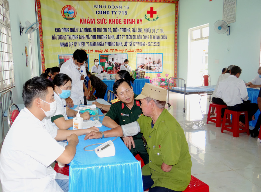 Đại tá Nguyễn Phúc Khính (thứ 2 bìa phải)-Giám đốc Công ty 715 thăm hỏi, động viên thương binh Rơ Châm Teng (làng Mít Jép, xã Ia O, huyện Ia Grai). Ảnh: Đinh Yến