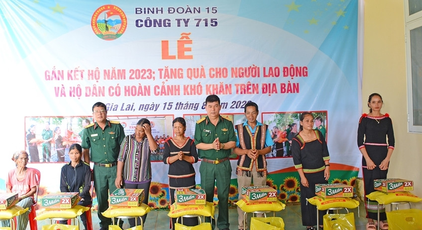 Lãnh đạo Công ty 715 tặng quà cho lao động, hộ dân có hoàn cảnh khó khăn trên địa bàn. Ảnh: Đinh Yến