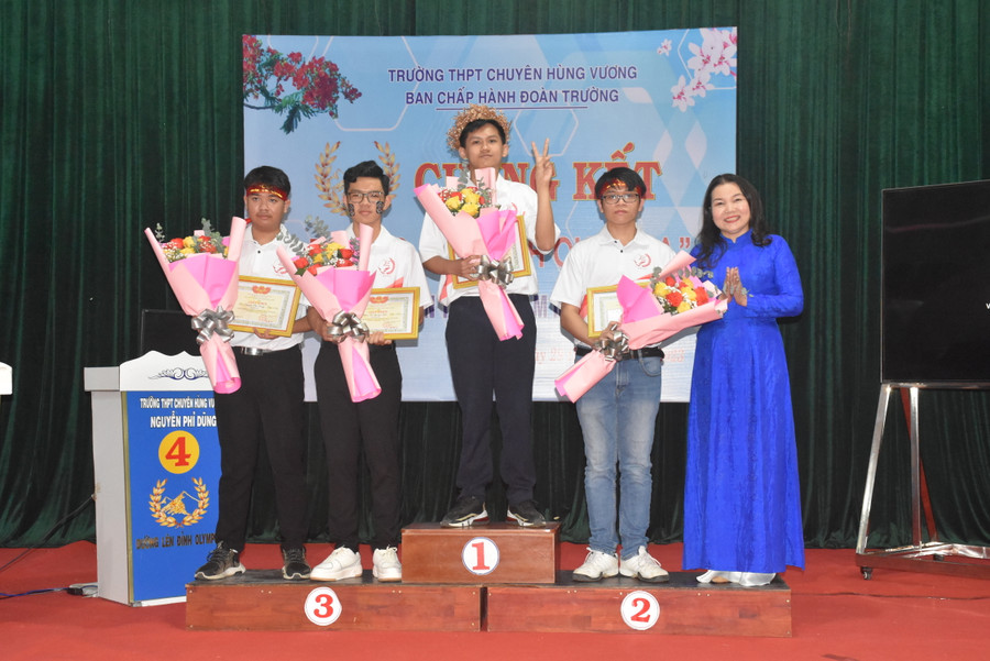 Em Nguyễn Quốc Nhật Minh (số 1) xuất sắc giành vòng nguyệt quế tại cuộc thi cùng 3 bạn được bà Lê Thị Thu-Hiệu trưởng Trường THPT chuyên Hùng Vương tặng giấy khen và hoa. Ảnh: Đinh Yến