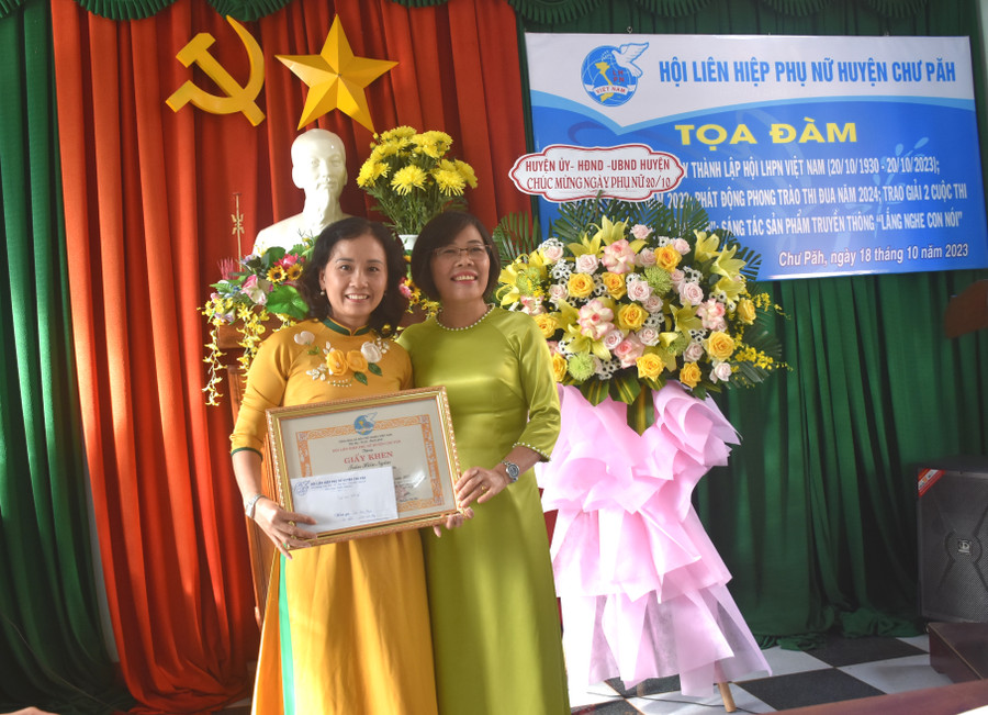 Bà Nguyễn Thị Bảy (bìa phải)-Chủ tịch Hội LHPN huyện Chư Păh trao giải nhất Cuộc thi vẽ tranh &quot;Sắc màu bình yên&quot; cho chị Trần Hiếu Ngân (Hội LHPN thị trấn Phú Hòa). Ảnh: Đinh Yến