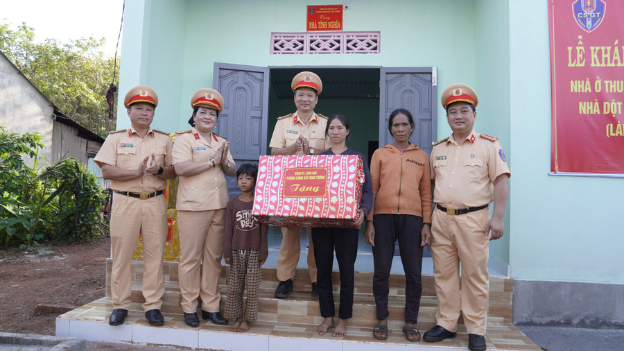 Lãnh đạo Phòng Cảnh sát Giao thông tặng quà cho hộ bà Siu Lĩ (trú tại làng Bang Ngol, xã Ia Tôr) khi về nhà mới. Ảnh: Nông Hòa dsc3779.jpg