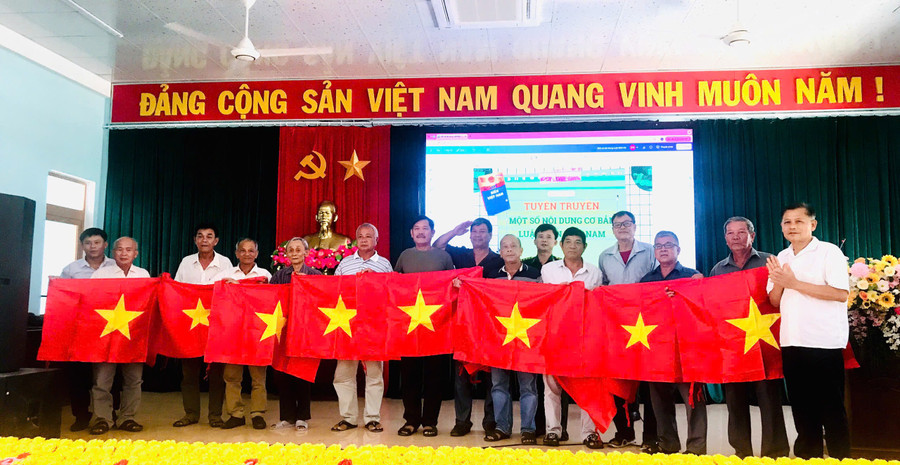 Lãnh đạo Sở Ngoại vụ Gia Lai tặng cờ Tổ quốc cho ngư dân xã Cát Tiến. Ảnh: Phi Long anh-2.jpg