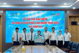 Ban lãnh đạo BIDV Gia Lai và Tổng Công ty Bảo hiểm BIDV chi trả quyền lợi bảo hiểm cho gia đình khách hàng Nguyễn Tất Minh. Ảnh Sơn Ca