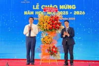 Phó Chủ tịch UBND tỉnh Lâm Hải Giang (bên trái) tặng hoa chúc mừng Trường Đại học Quang Trung tại lễ chào mừng năm học mới 2025-2026. 