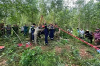 Các lực lượng phối hợp cứu người bị nạn lên khỏi miệng giếng. 