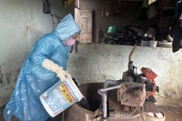 Cán bộ y tế khử khuẩn giếng nước bằng Cloramin B. 