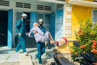 Xã Tuy Phước Đông hỗ trợ người cao tuổi đi lại khó khăn đến nơi tránh trú. Ảnh: ĐVCC