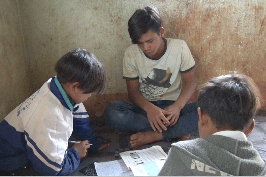 Tim đang hướng dẫn cho hai em học bài. Ảnh: T.T Tim đang hướng dẫn cho hai em học bài. Ảnh: T.T