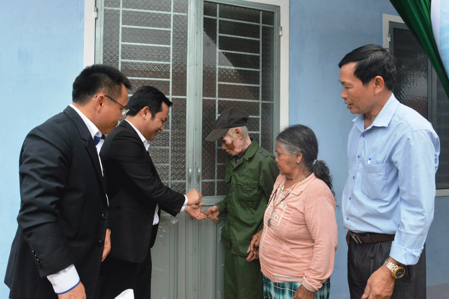 Đại diện Ngân hàng ACB trao chìa khóa nhà tình nghĩa cho gia đình ông Hrơn. Ảnh: N.T