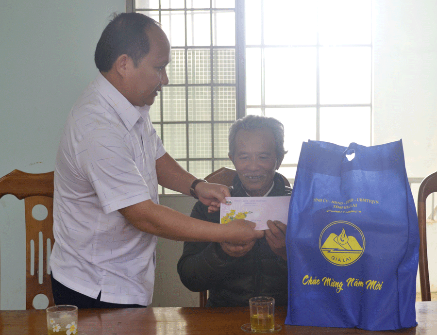 Trưởng ban Nội chính Tỉnh ủy Rah Lan Chung tặng quà Tết gia đình ông Phạm Văn Nguyên (tổ dân phố 3, thị trấn Kon Dơng). Ảnh: L.H