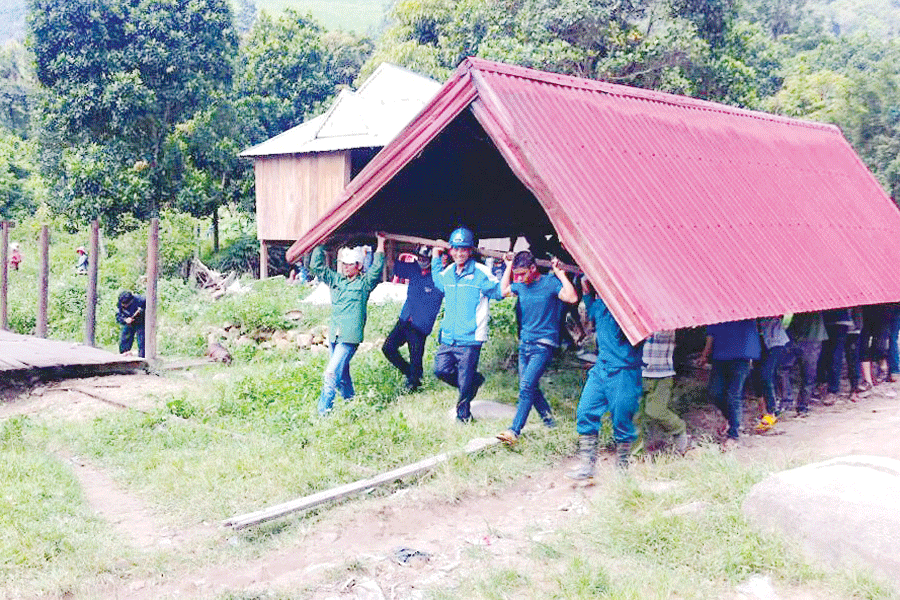 Giúp người dân làng Brang (xã Đak Pling) di dời nhà ra khỏi vùng có nguy cơ sạt lở. Ảnh: internet