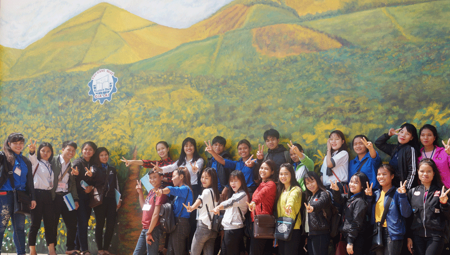 Học sinh, sinh viên hào hứng chụp ảnh bên bức tranh đồi hoa dã quỳ tại tường nhà thi đấu của trường. Ảnh: T.N.Đ Học sinh, sinh viên hào hứng chụp ảnh bên bức tranh đồi hoa dã quỳ tại tường nhà thi đấu của trường. Ảnh: T.N.Đ