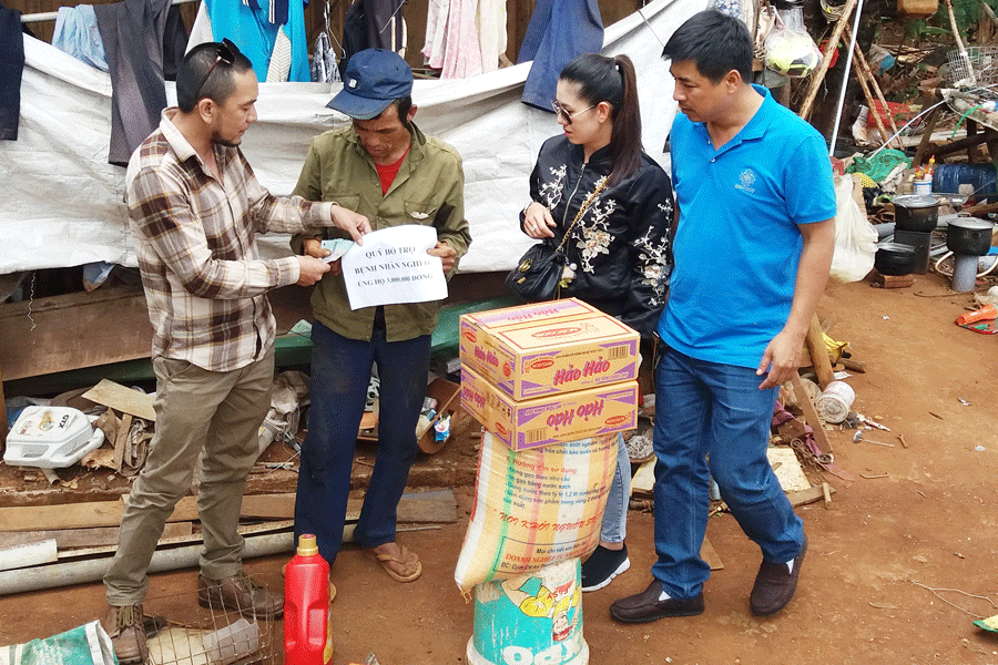 Các tình nguyện viên trao quà cho ông Liêm (người đội mũ). Ảnh: N.N Các tình nguyện viên trao quà cho ông Liêm (người đội mũ). Ảnh: N.N