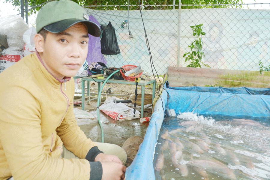 Anh Đoàn Vĩnh Lộc bên lồng cá nuôi ỏ lòng hồ thủy điện An Khê-Ka Nak. Ảnh: H.Đ.T