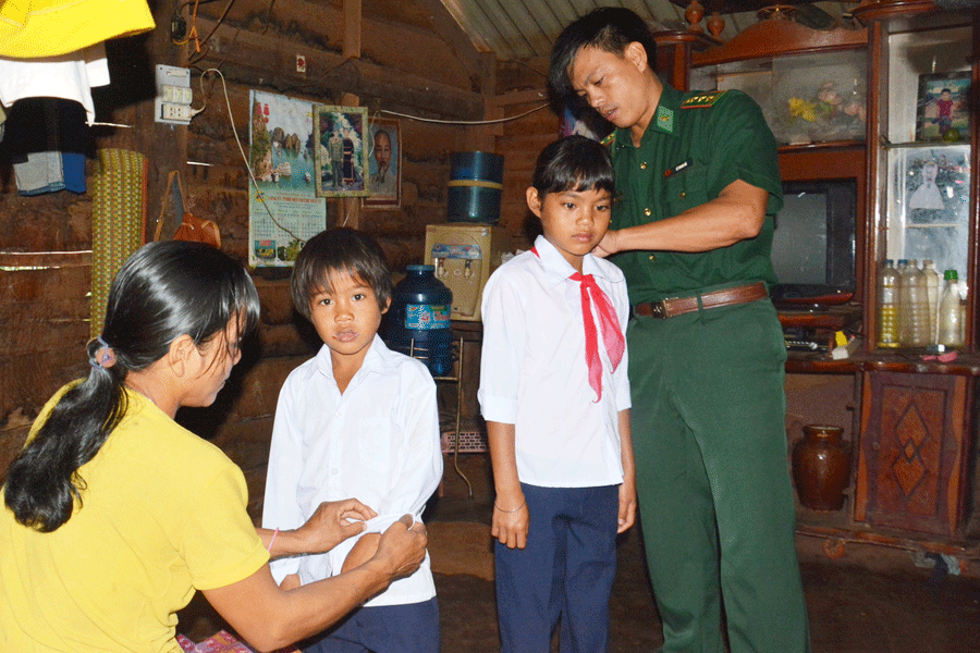Thượng úy Lê Thanh Hải (Đồn Biên phòng Ia Nan) tới giúp chuẩn bị đưa em Rơ Châm H’Bình đến trường. Ảnh: Lê Anh