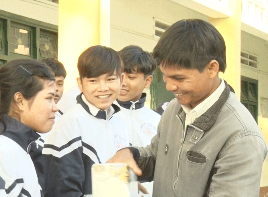 Thầy Đinh Xuân Hiến trao quà cho các em học sinh có hoàn cảnh khó khăn. Ảnh: Hà Duyệt