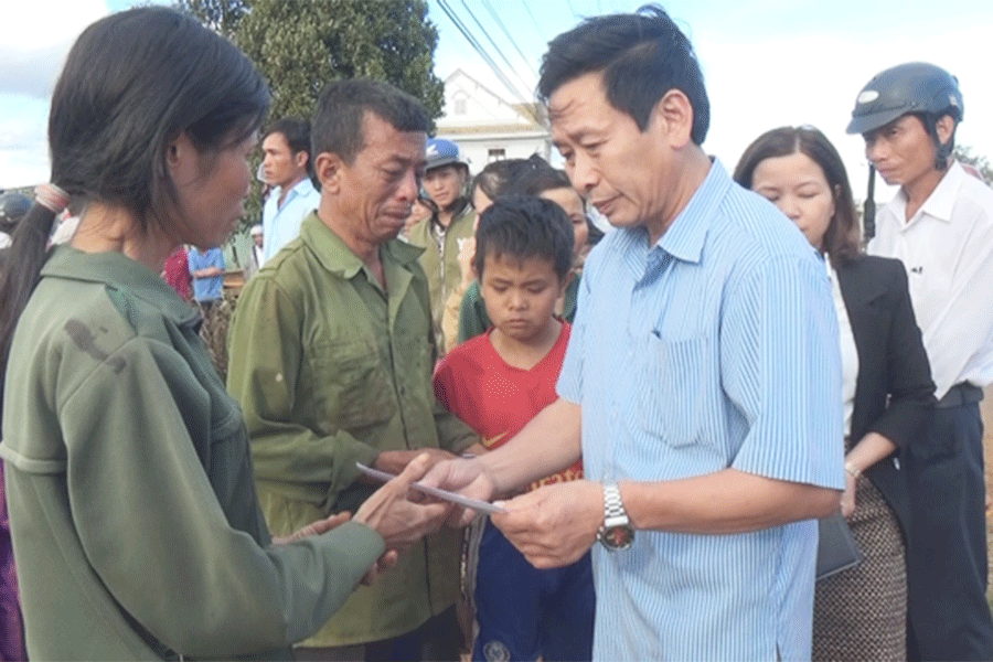 Ông Bùi Viết Hội- Bí thư Huyện ủy Chư Prông trao tiền hỗ trợ gia đình bị cháy nhà. Ảnh: Rơ Lan Viện