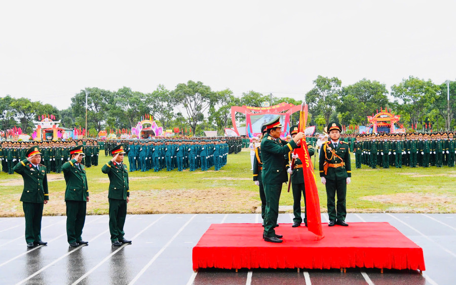 Thượng tướng Võ Minh Lương gắn Huân chương bảo vệ Tổ quốc hạng nhất lên Quân kỳ Quyết thắng. Ảnh: P.D z7135427693774-f6714b1b98ad17de76204337747c6979.jpg
