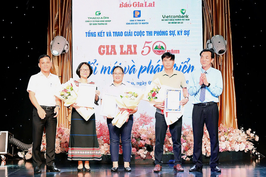 Phó Tổng Biên tập Báo Gia Lai Lương Văn Danh (bên phải) và đại diện nhà tài trợ trao giải ba cho các tác giả, nhóm tác giả . Ảnh: Đ.T z6584690675131-3961424da133655973d2abecaa00fdb0.jpg