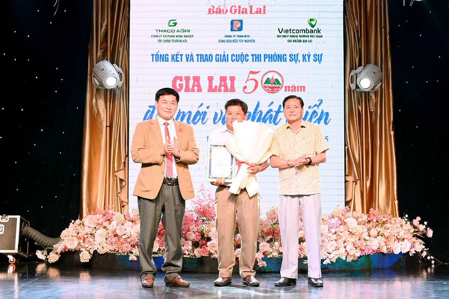 Giám đốc Sở Văn hóa-Thể thao và Du lịchTrần Ngọc Nhung (bìa phải) và Tổng Biên tập Báo Gia Lai Huỳnh Kiên (bìa trái) trao giải nhất cuộc thi. Ảnh: Đ.T z6584683968867-7fc45c8eaf519cfe656411d75eee744d.jpg
