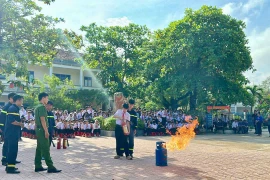 Học sinh được hướng dẫn cách sử dụng bình chữa cháy xách tay. Ảnh: N.L