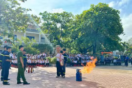 Học sinh được hướng dẫn cách sử dụng bình chữa cháy xách tay. Ảnh: N.L