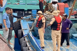 Cảnh sát đường thủy vận động các ngư dân neo đậu tàu thuyền. Ảnh: N.L