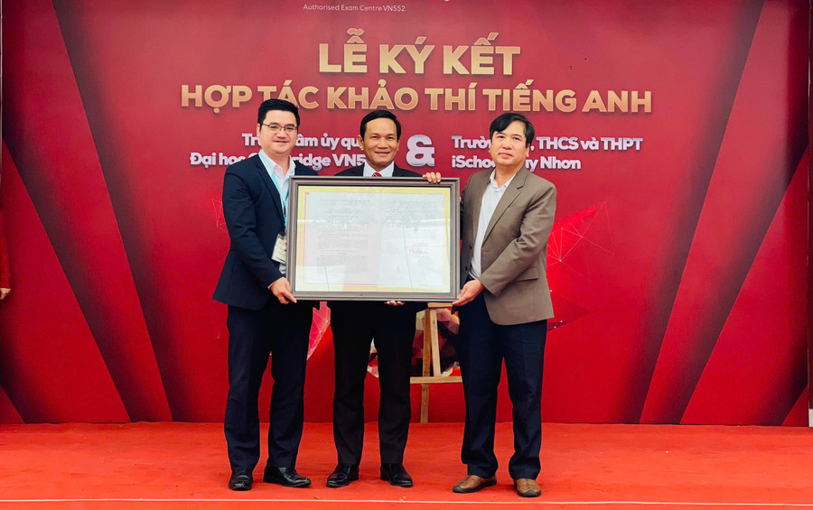 Ông Trần Bá Công-Phó Giám đốc Sở GD-ĐT (bìa phải) trao quyết định của Bộ GD-ĐT về việc công nhận điểm thi Cambridge cho Trường Tiểu học, THCS và THPT iSchool Quy Nhơn. Ảnh: T.D 010119680d298677df38.jpg