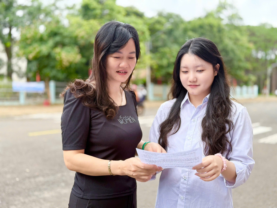 Em Mai Thị Bảo Ngọc (thí sinh tại điểm thi Trường THPT Trần Hưng Đạo, huyện Mang Yang) trao đổi đề thi với phụ huynh sau buổi thi. Ảnh: Lạc Hà nv-tuyet.jpg