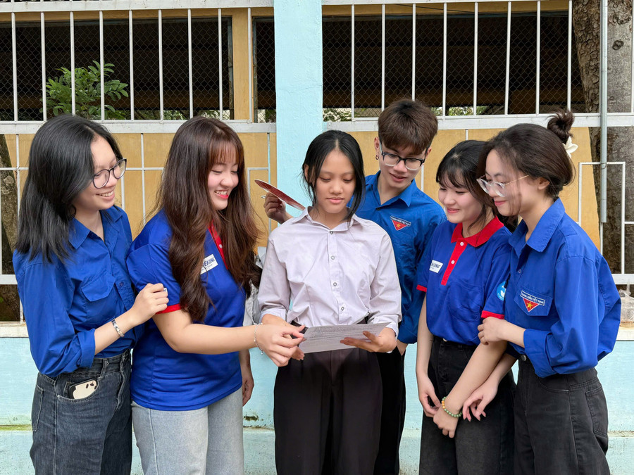 Em Đào Ngọc Oanh (thứ 3 từ trái sang, thí sinh tại điểm thi Trường THPT Trần Hưng Đạo) chia sẻ cảm xúc với các tình nguyện viên tiếp sức mùa thi sau khi kết thúc môn Ngữ Văn. Ảnh: Ngọc Duy nv-duy-8396.jpg