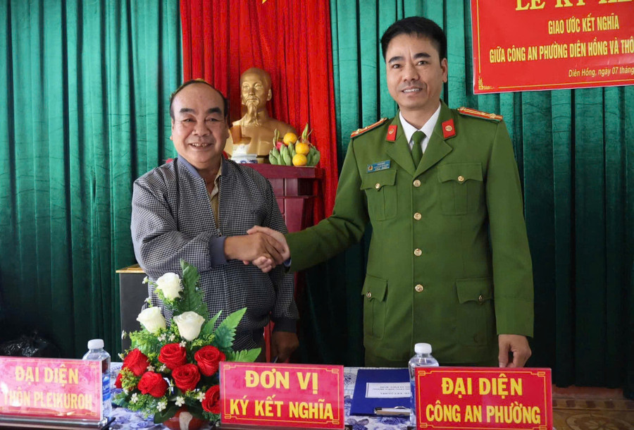 Locotenent-colonelul Ksor Dinh - șeful poliției din districtul Dien Hong și domnul Do Van Loi - secretarul celulei de partid din satul Pleiku Roh au semnat acordul de înfrățire dintre cele două unități. Foto: DVCC z7302943976534-2fd2adf6d5c6e11b0312d27f49df174e.jpg