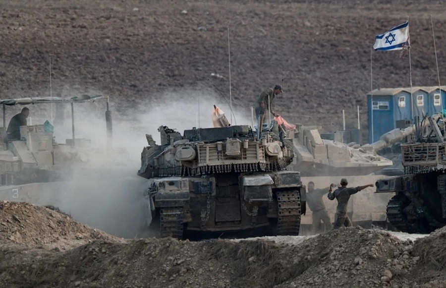 Binh lính Israel làm việc trên xe tăng, gần biên giới với Gaza. Ảnh: Reuters g4.jpg