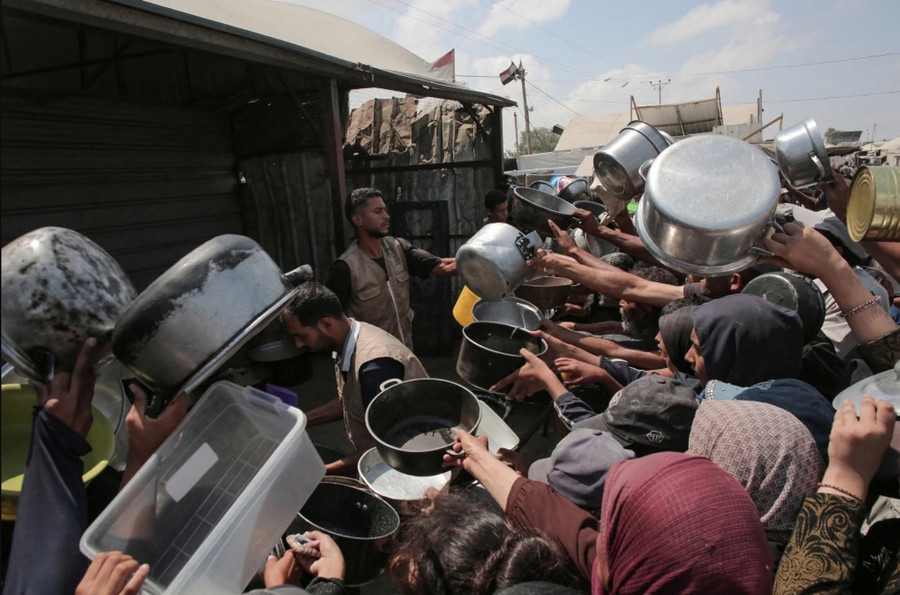 Người dân Palestine giơ những chiếc nồi rỗng trước một bếp ăn từ thiện ở Khan Yunis, phía nam Dải Gaza ngày 21-8. Ảnh: AFP g2.jpg