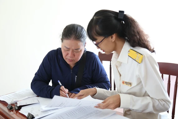 Công chức Thuế cơ sở 1 tư vấn, hướng dẫn hộ kinh doanh chuyển đổi từ phương pháp khoán sang phương pháp kê khai. Ảnh: T.SỸ