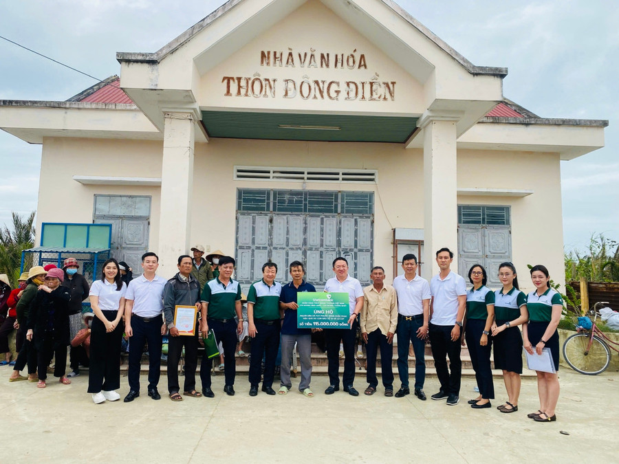 Đại diện Vietcombank chi nhánh Bình Định và chi nhánh Thống Nhất (TP Hồ Chí Minh) hỗ trợ 115 triệu đồng cho người dân xã Tuy Phước Đông khắc phục hậu quả thiên tai. Ảnh: Nhật Trường