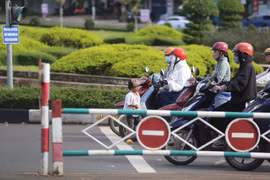 Cậu bé 5 tuổi ra giữa lòng đường để xin tiền người dân đang dừng đèn đỏ. Ảnh: Văn Ngọc