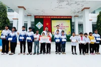 Thầy Vũ Văn Tùng phối hợp với Ban Giám hiệu Trường Tiểu học và THCS Đinh Núp tặng học bổng cho học sinh nghèo vượt khó của trường. Ảnh: Văn Tùng