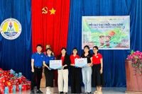 Đại diện Quỹ Hy vọng và Công ty Cổ phần bán lẻ Kỹ thuật số FPT trao kinh phí và trang thiết bị dạy học hỗ trợ Trường Tiểu học và THCS Nguyễn Viết Xuân tái thiết sau bão. Ảnh: Vũ Chi