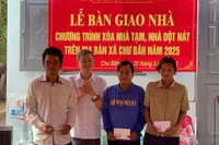 Bí thư Thị ủy Ayun Pa Trần Quốc Khánh (thứ 2 từ trái sang) tặng quà cho các hộ dân được bàn giao nhà thuộc chương trình xóa nhà tạm, nhà dột nát xã Chư Băh. Ảnh: Vũ Chi