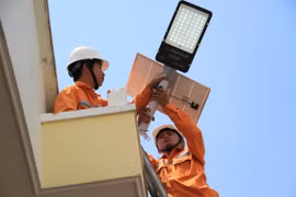 Các nhân viên Công ty Điện lực Gia Lai lắp đèn điện cho công trình “Thắp sáng đường quê” cho buôn Ngôl. Ảnh: Hoàng Hoài