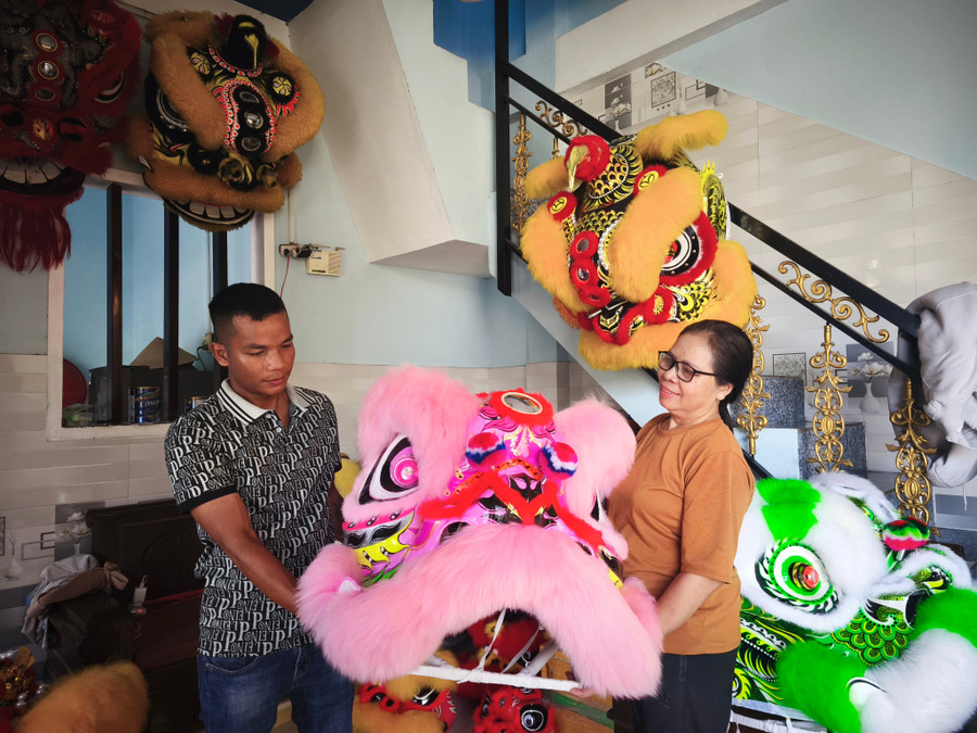 Anh Huỳnh Thanh Hoàng giao đầu lân cho khách. Ảnh: Đinh Ngọc 2.jpg