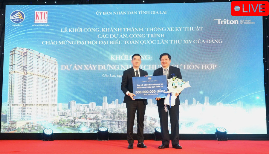 Ông Trần Ngọc Hà - Tổng Giám đốc Công ty cổ phẩn Arita (trái) đại diện chủ đầu tư Dự án trao bảng tượng trưng hỗ trợ 500 triệu đồng cho người dân tỉnh Gia Lai khắc phục hậu quả thiên tai. Ảnh: Huỳnh Vỹ